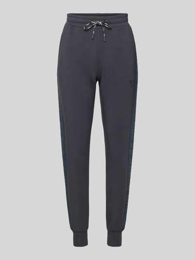 Produktfoto, Sweatpants mit elastischem Bund Modell 'ALLIE' von Guess Activewear, ciemnoszary kolor, luźny krój, viskose z dodatkiem stretchu, tunel ze sznurkiem, francuskie kieszenie, długość nogawki wewnętrznej w rozmiarze S: 36 cm