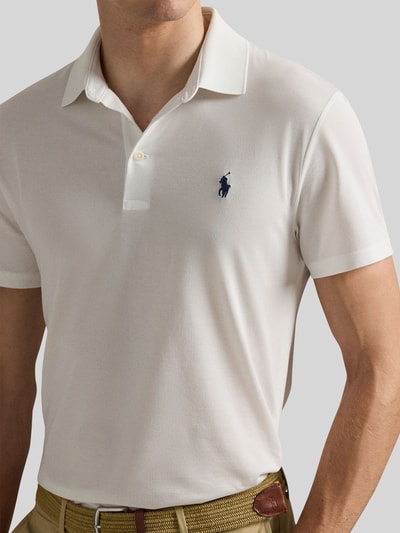 Männermodel trägt Regular Fit Poloshirt aus Baumwoll-Mix Modell 'TOUR PIQUE' von Polo Ralph Lauren, Optik: Unifarben, Logo-Detail, Polokragen, V-Ausschnitt, kurze Knopfleiste, Kurzarm, Rumpfabschluss mit Seitenschlitzen, Materialverarbeitung: Piqué, Nahaufnahme Oberkörper.
