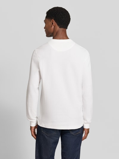 Männermodel trägt Regular Fit Langarmshirt aus reiner Baumwolle von Lacoste in Weiß, glatte Textur, Ganzkörperansicht Rückansicht.