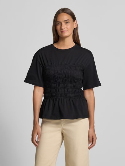 Frauenmodel trägt T-Shirt mit Smok-Details und Rundhalsausschnitt von Jake*s Casual aus Reine Baumwolle, Slim-Fit, schwarze Farbe, Ganzkörperansicht von vorne. Rückenlänge bei Größe S: 54 cm.