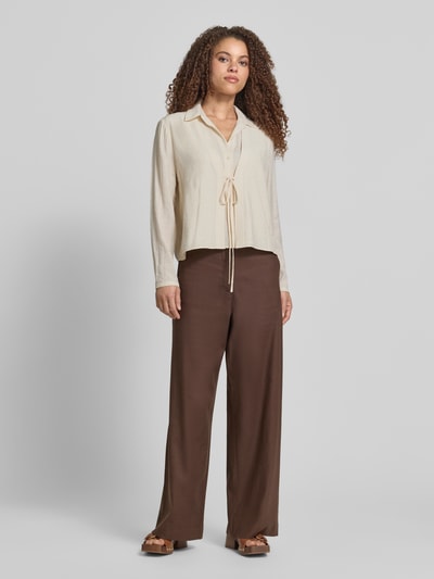 Frauenmodel trägt Bluse aus Viskose-Mix mit Binde-Detail von Jake*s Collection in Beige, Straight Fit, Umlegekragen, Knopfleiste, Ganzkörperansicht von vorne.
