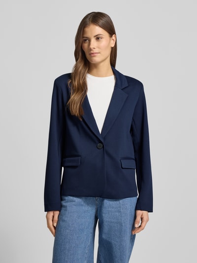 Modelka kobieca ma na sobie granatowy Regular Fit Blazer mit Viskose-Anteil Modell 'Nanni' od FREE/QUENT, elastyczny materiał, krój regular fit, kołnierz z klapami, jeden guzik, długość tyłu w rozmiarze S: 61 cm, szerokość w rozmiarze S: 50 cm, długość rękawa w rozmiarze S: 56 cm, tekstura gładka z matowym wykończeniem, widok na całą sylwetkę z przodu.