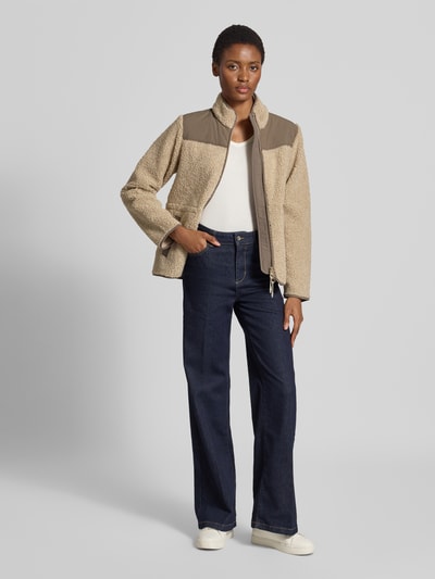 Frauenmodel trägt Fleecejacke mit Zweiwege-Reißverschluss Modell 'Elisa Eli' von MOS MOSH in Beige, lockere Passform, Ganzkörperansicht von vorne, Regular Fit, Stehkragen, Eingrifftaschen, moderne Streetwear.