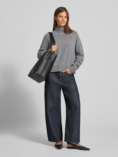 Frauenmodel trägt grauen Strickpullover mit Stehkragen Modell 'LYZIMA' von DRYKORN, reine Baumwolle, Regular Fit, Ganzkörperansicht von vorne.