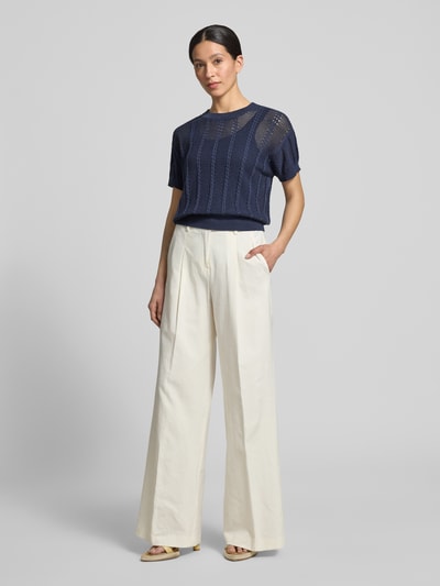 Frauenmodel trägt Relaxed Fit Strickshirt aus Baumwoll-Mix Modell 'LUX LIGHT' von Vero Moda, Optik: Unifarben, Lochstrickmuster, Rundhals, Kurzarm, Ärmelabschluss und Rumpfabschluss gerippt, Materialverarbeitung: Lochstrick, Ganzkörperansicht von vorne.