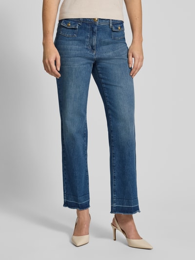 Frauenmodel trägt Jeans im Used-Look mit Fransen von LUISA CERANO aus Baumwoll-Elasthan-Mix, Straight Fit, blaue Textur, Nahaufnahme Oberkörper.