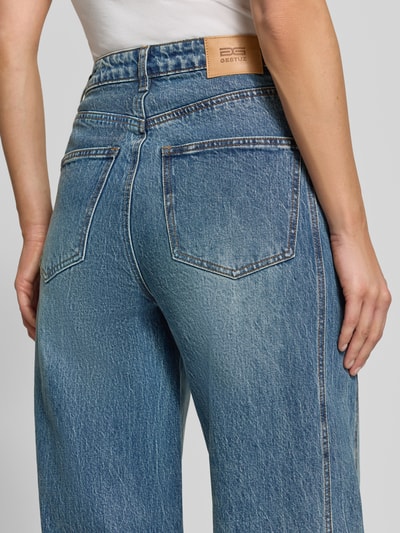 Frauenmodel trägt Barrel Fit Jeans aus Baumwoll-Mix Modell 'Melu' von GESTUZ, blau mit 5-Pocket-Design, Nahaufnahme Rückansicht. Damen Jeans, Baumwoll-Elasthan-Mix, Knopf- und Reißverschluss, Bundweite 39 cm, Innenbeinlänge 86 cm.