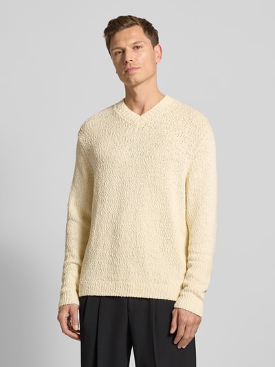 Männermodel trägt Regular Fit Strickpullover aus reiner Bio-Baumwolle Modell 'Angus' von SELECTED HOMME, Optik: Unifarben, Struktur, V-Ausschnitt, Langarm, Bündchen gerippt, Strick, Farbe creme, Ganzkörperansicht von vorne.