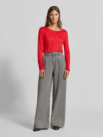 Frauenmodel trägt Longsleeve in semi-transparenter Optik von MYON, taillierter Schnitt, Rundhalsausschnitt, rote Farbe, Ganzkörperansicht von vorne.