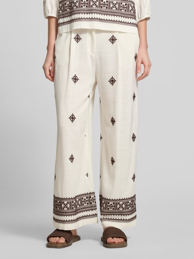 Frauenmodel trägt Hose aus Viskose-Leinen-Mix mit Stitchings von Christian Berg Woman Selection, cremefarben mit braunen Mustern, Regular-Fit, elastischer Bund, Bundweite bei Größe 36: 39 cm, Innenbeinlänge 69 cm, Nahaufnahme Unterkörper von vorne.