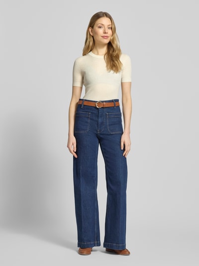 Vrouwenmodel draagt Regular Fit Strick-Shirt aus reiner Wolle van Lacoste, look: effen, regular fit, gestikt logo, ronde hals, korte mouw, geribd, fijn ribtricot, materiaal: wol. Ganzkörperansicht van voren.