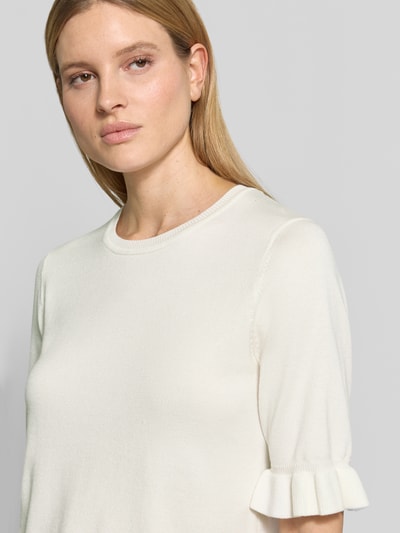 Frauenmodel trägt Regular Fit T-Shirt aus Viskose-Mix Modell 'Katie' von FREE/QUENT in Creme mit Rüschenbesatz und Strick-Optik, Nahaufnahme Oberkörper.
