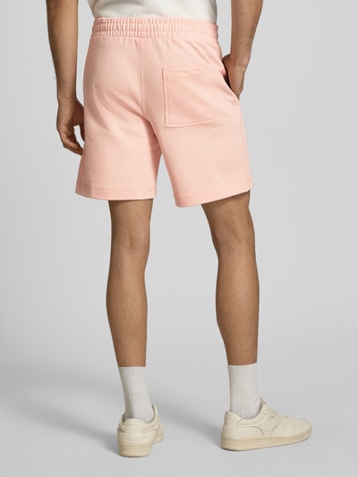 Männermodel trägt Sweatshorts mit Stitching Modell 'KARL' von Jack & Jones in Hellrosa, Baumwoll-Mix, elastischer Bund, Ganzkörperansicht Rückansicht
