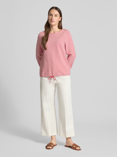 Frauenmodel trägt Regular Fit 3/4-Shirt aus Bio-Baumwoll-Mix von Tom Tailor mit rot-weißen Streifen, Rundhals, Rippstruktur, Ganzkörperansicht von vorne.