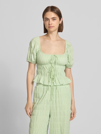 Frauenmodel trägt Blusentop mit Schnürung Modell 'Noemi' von OH APRIL, reine Baumwolle, Slim Fit, Karree-Ausschnitt, hellgrün, Nahaufnahme Oberkörper.