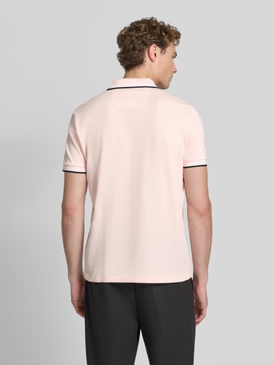 Mężczyzna model nosi jasnoróżową koszulkę polo Regular Fit Poloshirt aus reiner Baumwolle model 'PADDY' od BOSS Green, gładka tekstura, całkowity widok z tyłu.