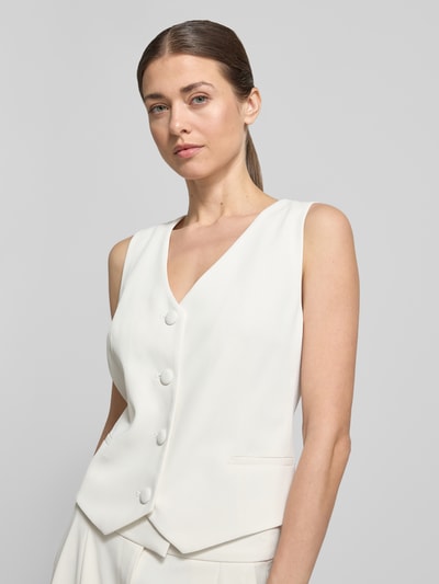 Vrouwenmodel draagt Regular Fit bodywarmer met V-hals van Christian Berg Cocktail, elastische materiaalmix, knoopsluiting, ruglengte maat 36: 46 cm, nahaufnahme bovenlichaam.