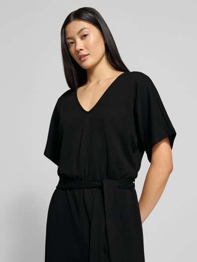 Frauenmodel trägt Jumpsuit mit Bindegürtel Modell 'Renata' von GUIDO MARIA KRETSCHMER WOMAN in Schwarz, V-Ausschnitt, Nahaufnahme Oberkörper, Viskose-Mix mit Stretch-Anteil, Relaxed Fit.