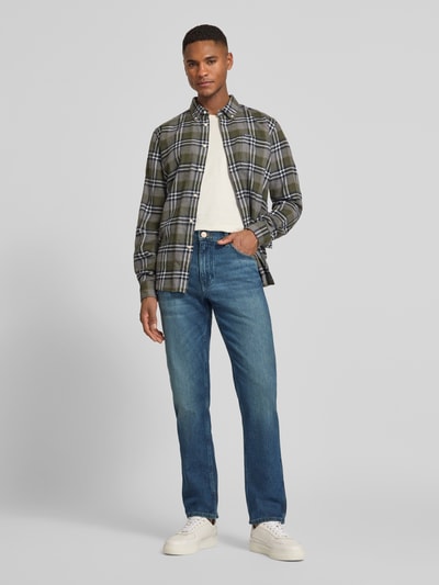 Männermodel trägt Straight Fit Jeans im 5-Pocket-Design Modell 'Greensboro' von Wrangler aus Baumwoll-Mix mit Stretch-Anteil, Gerader-Schnitt, mittleres Blau, dezente Waschung, Knopf-Reißverschluss, Ganzkörperansicht von vorne.