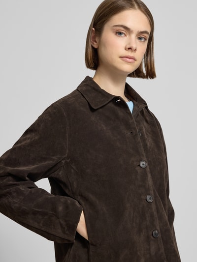 Vrouwenmodel draagt Jacke in Leder-Optik mit Kentkragen Modell 'Trine' van Gina Tricot, materiaal mix met viscose, recht model, leerlook, kentkraag, knoopsluiting, detailopname bovenlichaam.