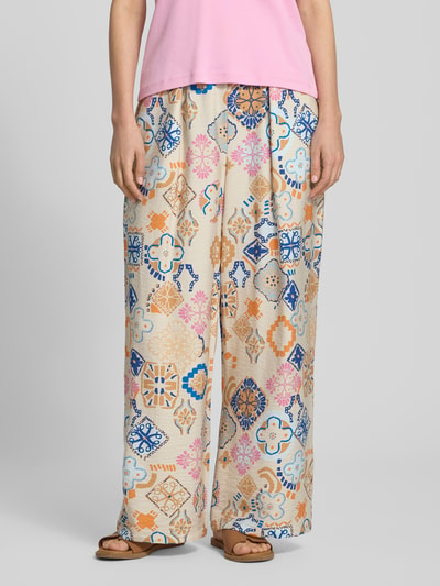 Frauenmodel trägt Wide Fit Stoffhose aus Viskose-Mix Modell 'Lancie' von ICHI mit floralem Allover-Print, bunte Farben, Nahaufnahme Unterkörper.