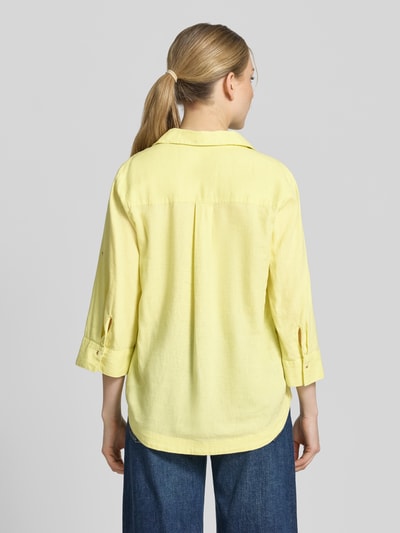 Frauenmodel trägt Relaxed Fit Hemdbluse aus Leinen-Viskose-Mix von s.Oliver RED LABEL in Gelb, Rückenpasse mit Cacharel-Falte, Ganzkörperansicht Rückansicht.