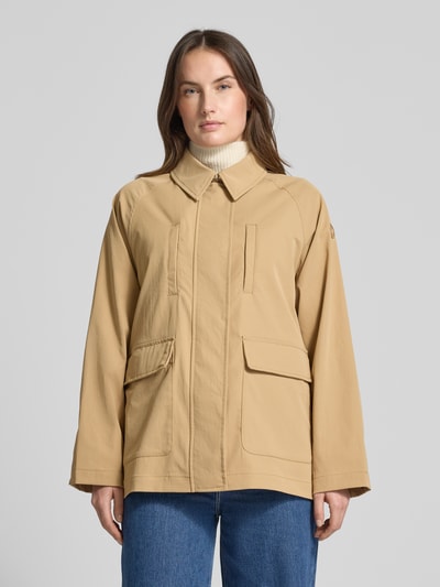 Frauenmodel trägt Relaxed Fit Jacke mit Umlegekragen Modell 'Dani' von SAVE THE DUCK in Beige, mit Brust- und aufgesetzten Taschen, Logo-Applikation, Reißverschluss mit Abdeckleiste, Ganzkörperansicht von vorne.