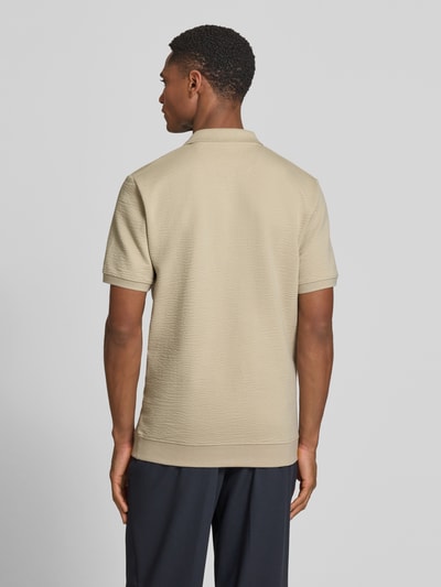 Männermodel trägt Regular Fit Poloshirt aus Baumwoll-Mix von s.Oliver RED LABEL, sandfarben, strukturierte Seersucker-Oberfläche, Ganzkörperansicht Rückansicht.
