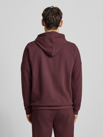 Männermodel trägt Regular Fit Hoodie aus Baumwoll-Mix Modell 'AUSTIN' von HUGO in Waffel-Struktur, unifarben, Ganzkörperansicht Rückansicht.