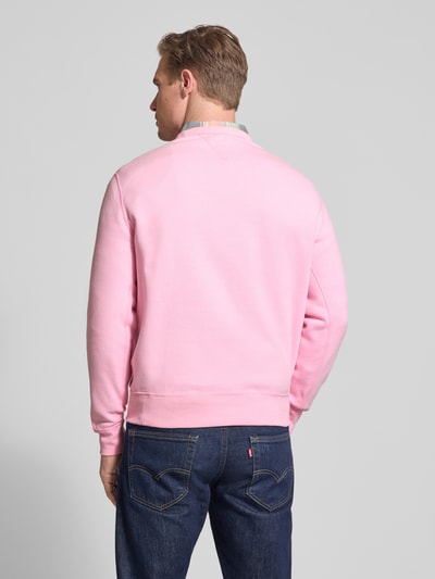 Mannenmodel draagt Regular Fit Sweatshirt uit katoenmix van Polo Ralph Lauren, look: effen, pasvorm: regular fit, logodetail, ronde hals, lange mouw, mouwboord en rompzoom: geribd, materiaalverwerking: sweat, kleur: roze, katoenmix, geheel zicht van achteren