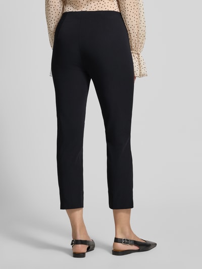 Frauenmodel trägt Caprihose mit Längsnähten Modell 'CAPRI' von SEDUCTIVE, schwarze Farbe, Material-Mix, Ganzkörperansicht Rückansicht.