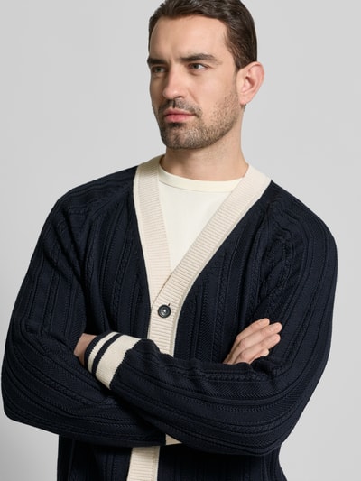 Männermodel trägt Cardigan mit V-Ausschnitt und Knopfleiste von PAUL SMITH, Reine Baumwolle, Regular-Fit, Dunkelblau mit Kontrast, Nahaufnahme Oberkörper.