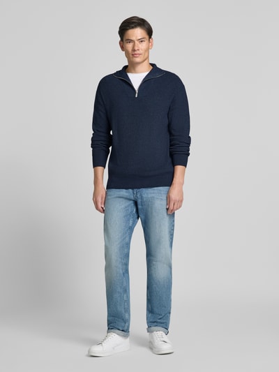 Männermodel trägt dunkelblauen Regular Fit Troyer aus Viskose-Mix von Jake*s Studio Men, kombiniert mit Jeans und Sneakern, Ganzkörperansicht von vorne.