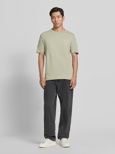 Männermodel trägt Regular Fit T-Shirt aus reiner Baumwolle Modell 'DERO222' von HUGO, Optik: Unifarben, Label-Print, Ganzkörperansicht von vorne.