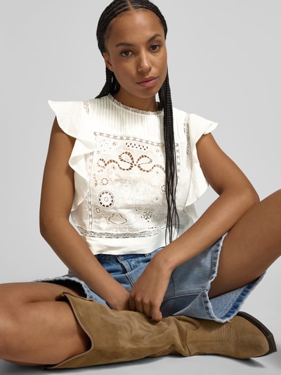 Frauenmodel trägt Crop Top mit Spitzen-Anteil von Self-Portrait, strukturierte weiße Oberfläche, ärmellos, Rundhalsausschnitt, Nahaufnahme Oberkörper.