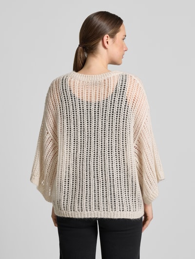 Frauenmodel trägt Loose Fit Pullover aus Woll-Mix von BOSS Orange, cremefarben, grobes Strickmuster, Ganzkörperansicht Rückansicht.