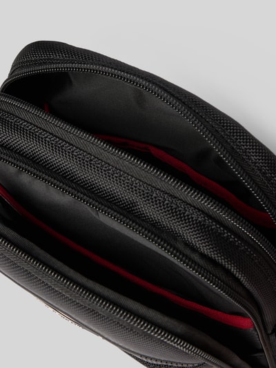 Produktfoto, Crossbody Bag mit Logo-Detail Modell 'Pro DLX' von Samsonite, schwarzes Material, mehrere Fächer, Reißverschlüsse, rote Innenfutter. Geteiltes Hauptfach, verstellbarer Trageriemen, Maße 19x27x8 cm, Länge Schulterriemen 90 cm.