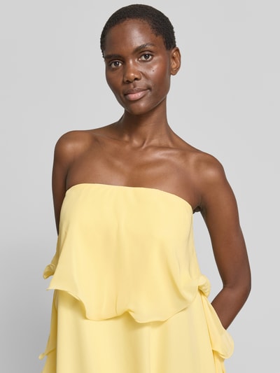 Vrouwenmodel draagt Maxikleid aus Chiffon Modell 'IRIS' van Vero Moda, look: effen, regular fit, maxilengte, zonder bandjes, volants, ruchedetail, materiaalverwerking: chiffon, kleur lichtgeel. Nahaufnahme bovenlichaam.