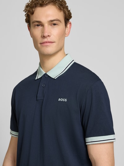 Männermodel trägt Regular Fit Poloshirt aus reiner Baumwolle Modell 'BLOCKS' von BOSS Orange, Optik: Unifarben, Nahaufnahme Oberkörper.