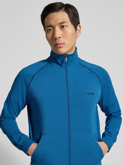 Männermodel trägt Regular Fit Sweatjacke aus Baumwoll-Mix Modell 'Mix&Match' von BOSS, Farbe Blau, Optik: Unifarben, Label-Stitching, Kontraststreifen, Stehkragen, Langarm, Reißverschluss, Materialverarbeitung: Sweat, Nahaufnahme Oberkörper.