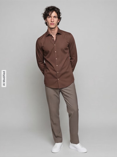 Männermodel trägt Slim Fit Businesshemd aus reiner Baumwolle von Seidensticker in Braun, glatte Textur, helle Hose, Ganzkörperansicht von vorne.