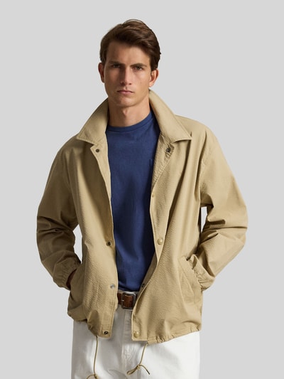 Mannenmodel draagt Regular Fit blouson uit katoenmix model 'SEERSUCKER' van Polo Ralph Lauren, look: effen, gestreept motief, platte kraag, drukknoopsluiting, gestikt logo, lange mouw, mouwboord elastisch, rompzoom met tunnelkoord, zij-ingezette steekzakken, materiaalverwerking: twill-stretch. Opname: close-up bovenlichaam.