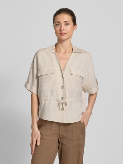 Modelka kobieca nosi Hemdbluse aus Leinen-Viskose-Mix od Christian Berg Woman Selection, kolor beżowy, z kołnierzykiem, guzikami, tunelem w talii, półrękawy, długość tyłu w rozmiarze 36: 56 cm, szerokość w rozmiarze 36: 55 cm, długość rękawa w rozmiarze 36: 28 cm, widok na cały przód.