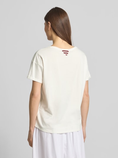 Kobiece model prezentuje damski t-shirt z obszyciem kamieniami stras T-Shirt mit Strasssteinbesatz od Oui, bawełna, prosty krój, dekolt w łódkę, długość tyłu w rozmiarze 36: 60 cm, zdjęcie całej sylwetki z tyłu.