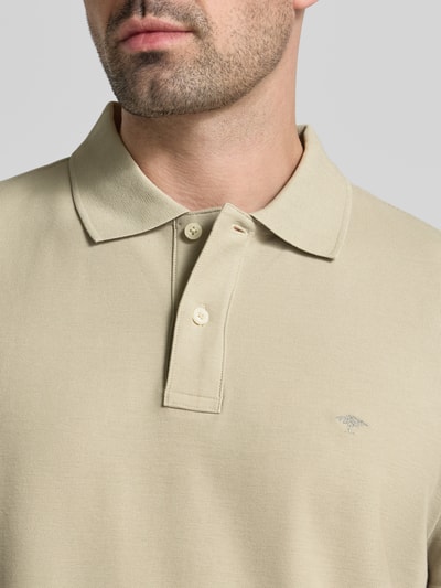 Männermodel trägt Regular Fit Poloshirt mit Label-Stitching von Fynch-Hatton aus Reine Baumwolle, Knopfleiste, Nahaufnahme Oberkörper. Rückenlänge bei Größe M: 72 cm.