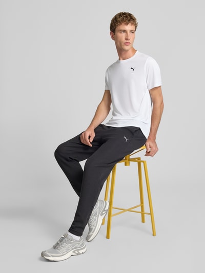 Männermodel trägt weißes Regular Fit Sport-T-Shirt mit Logo-Print Modell 'TAD Essential' von PUMA, Herren Sport-T-Shirt, Ganzkörperansicht von vorne.