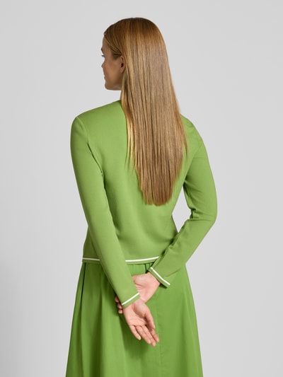 Frauenmodel trägt Cardigan aus Viskose-Mix mit Kontrastkante von Marc Cain in Grün mit Gerader-Schnitt, Rückenlänge 51 cm, Ganzkörperansicht Rückansicht.