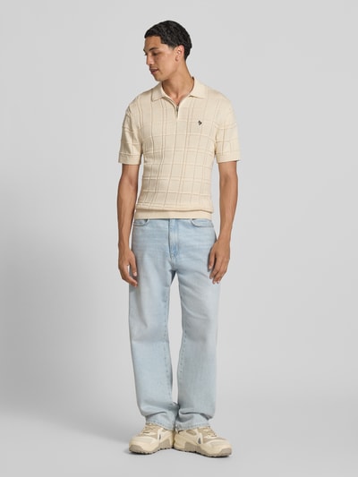 Männermodel trägt Modern Fit Poloshirt mit Logo-Stitching von REVIEW in Beige mit Strukturmuster, Reine Baumwolle, Ganzkörperansicht von vorne.