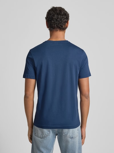 Męski model nosi T-shirt z wyhaftowanym logo od Lerros z bawełny, krój regular fit, prążkowany okrągły dekolt, długość tyłu 69 cm, widok całej sylwetki z tyłu.