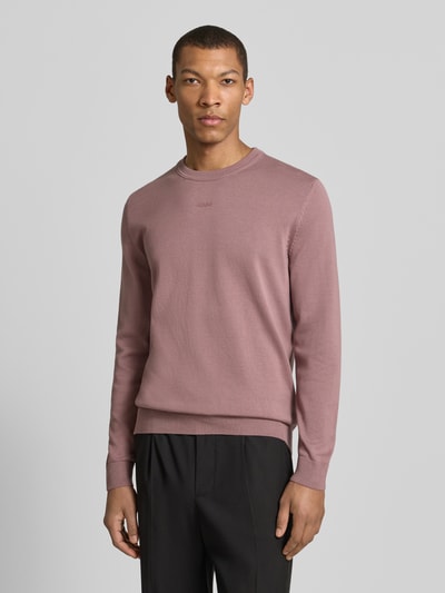 Męski model nosi Regular Fit Strickpullover aus reine Baumwolle Modell 'SAN CASSIUS-C2' od HUGO, kolor jednolity, krój regular fit, okrągły dekolt, długie rękawy, ściągacze, dzianina bawełniana, widoczny nadruk z logo, całkowity widok z przodu.